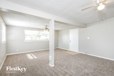 a living room with carpet and a ceiling fan