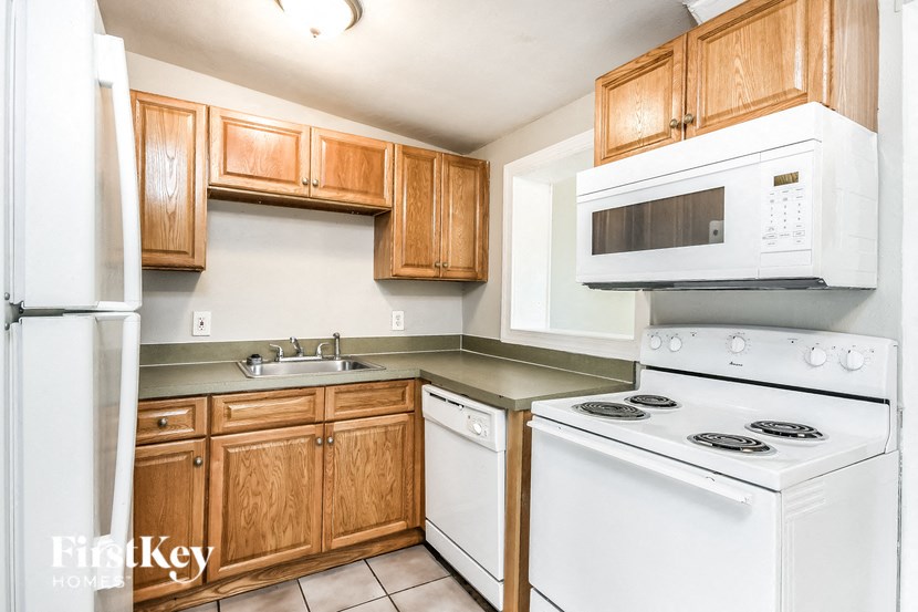 a kitchen with white appliances and wooden cabinets