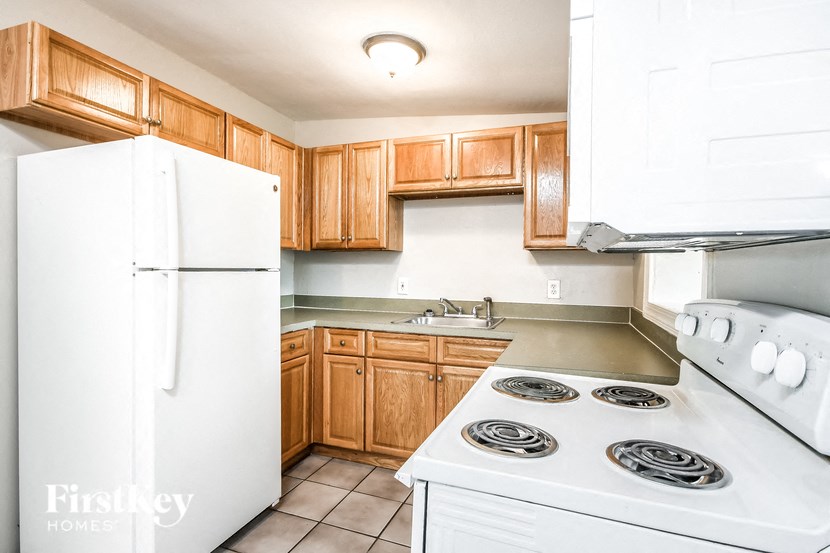a kitchen with white appliances and wooden cabinets