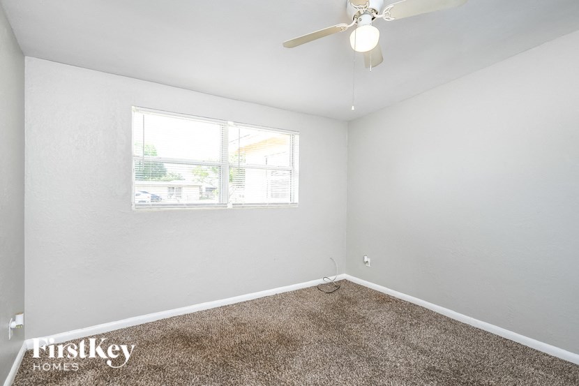 a bedroom with a ceiling fan and a window
