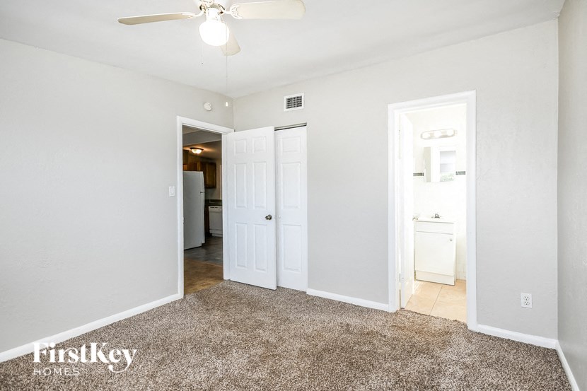 a bedroom with two closets and a ceiling fan