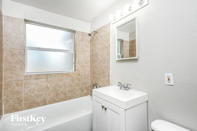 a bathroom with a sink toilet and tub and a mirror