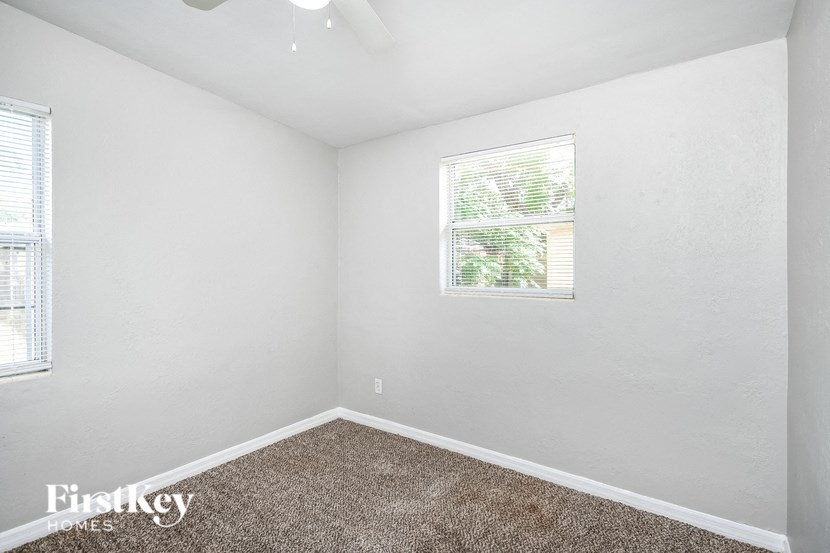 a bedroom with white walls and a window