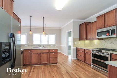 A kitchen with wooden cabinets and a stainless steel refrigerator.