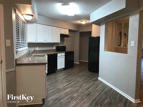 A kitchen with a black dishwasher and black refrigerator.