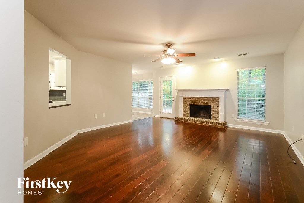 an empty living room with wood floors and a fireplace