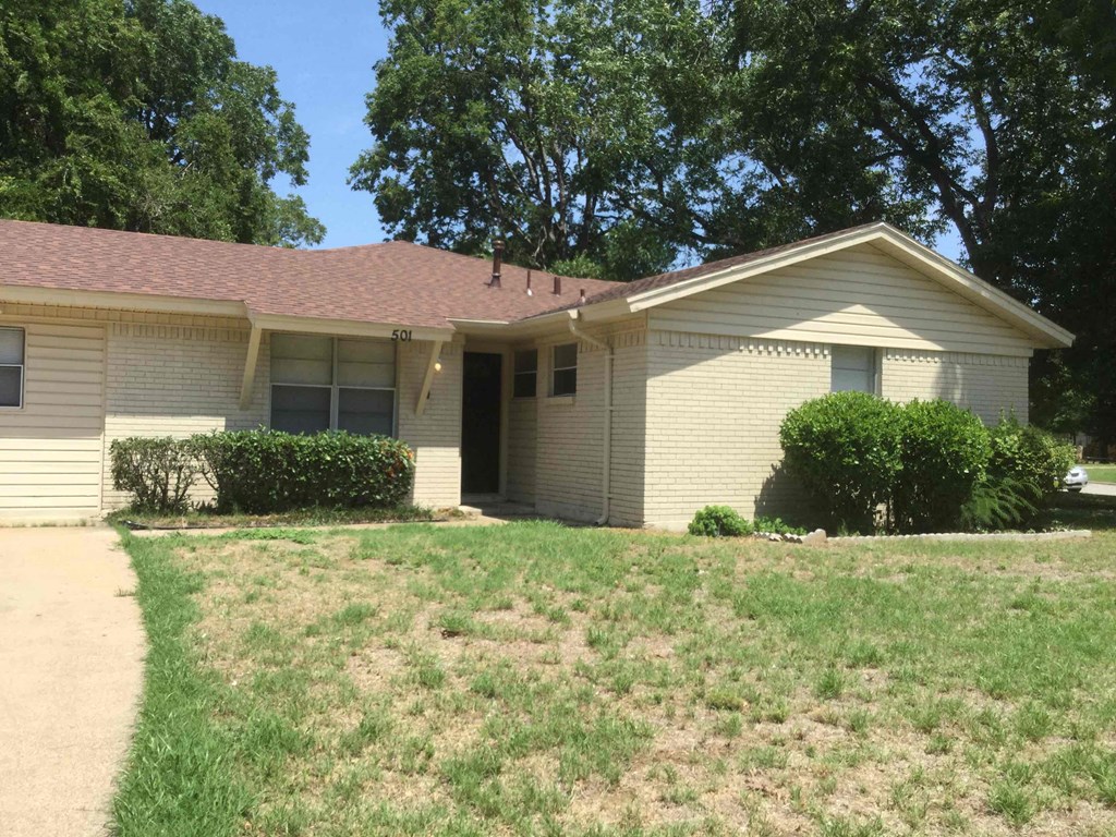 A house with a brown roof and a white wall with a window and a door.
