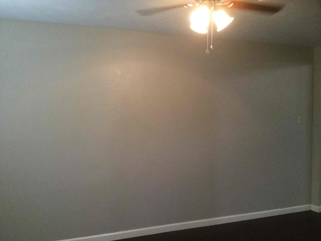 A room with a ceiling fan and a light fixture.