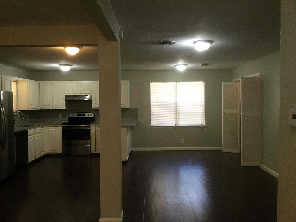 A kitchen with white cabinets and a stove top oven.