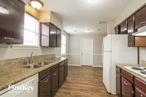 A kitchen with brown cabinets and a white refrigerator.