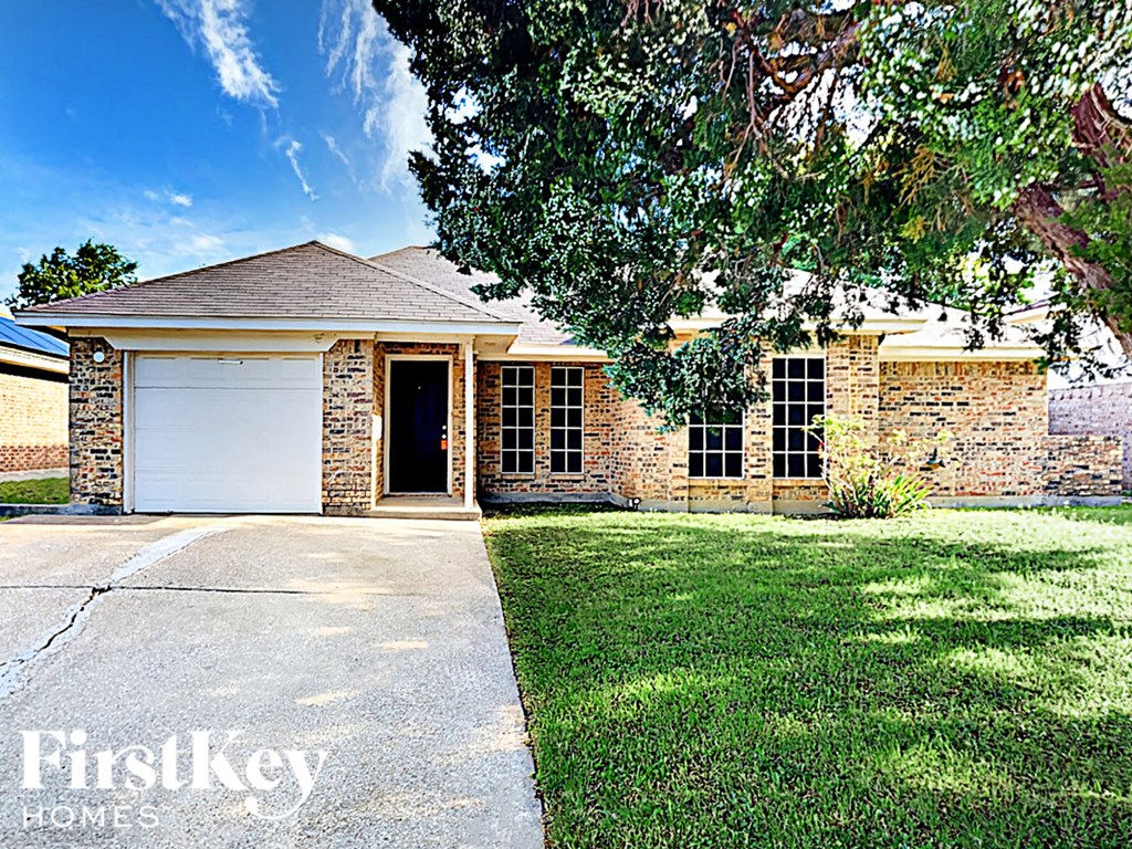 a small brick house with a white garage door