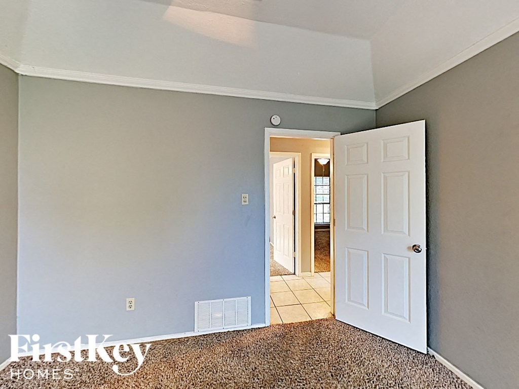 the bedroom door is open to the hallway and the bathroom