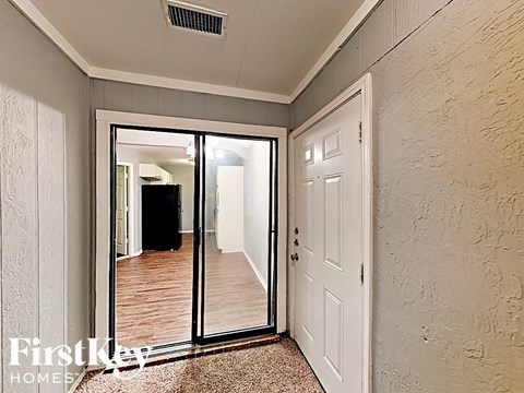 the master bedroom has a large mirror and a door to the hallway