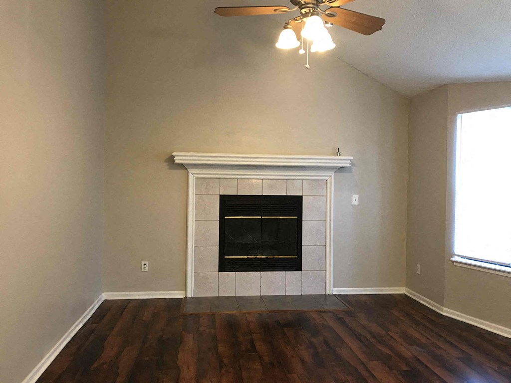 A room with a fireplace and a ceiling fan.