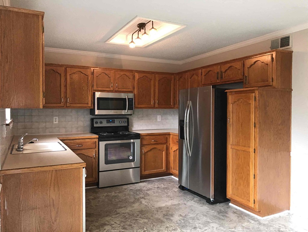 A kitchen with wooden cabinets and stainless steel appliances.