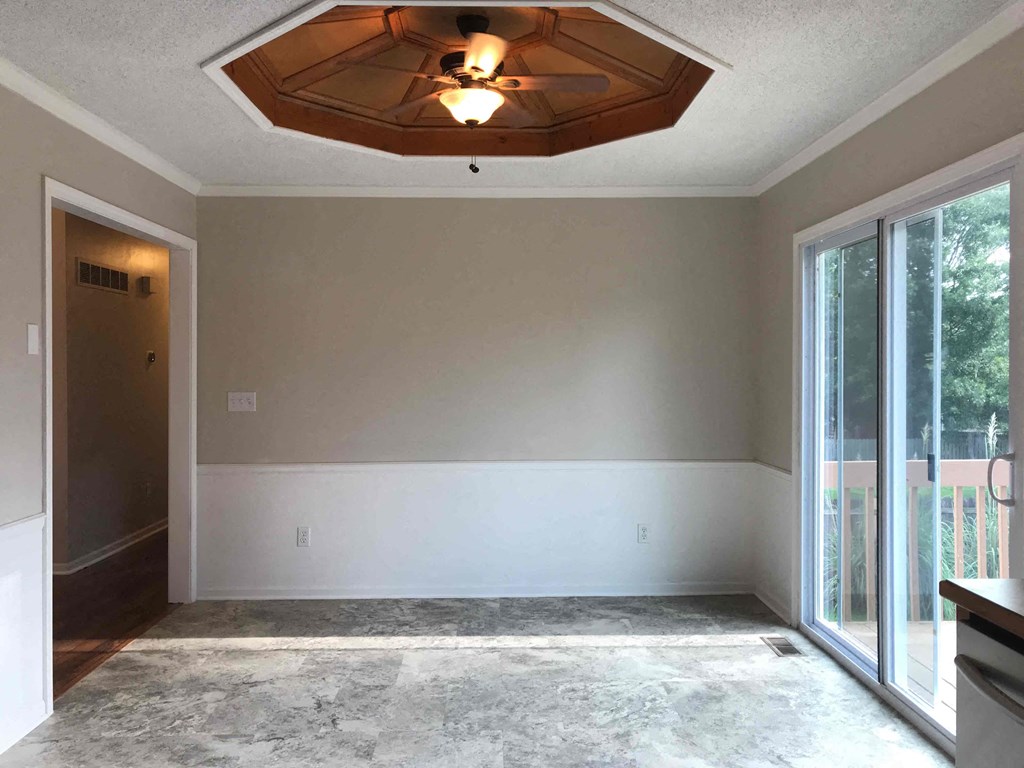 A room with a wooden ceiling and a sliding glass door.