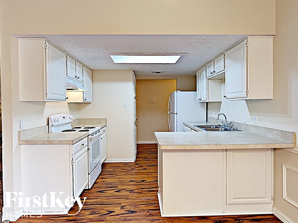 A kitchen with white appliances and cabinets.