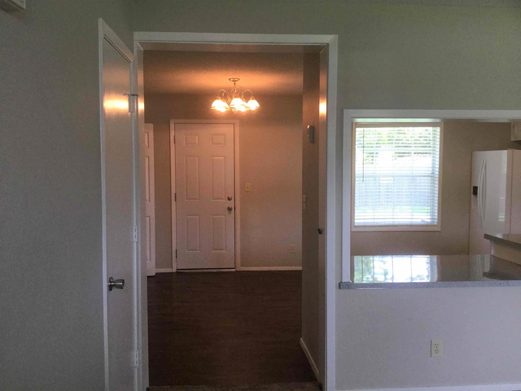 an empty room with a white door and a window