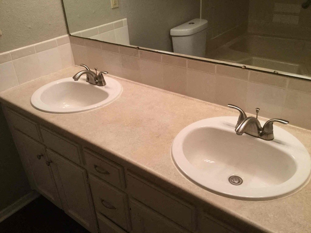 a bathroom with two sinks and a mirror