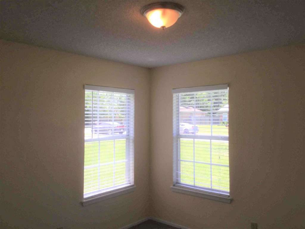 a living room with two windows and a light on the ceiling