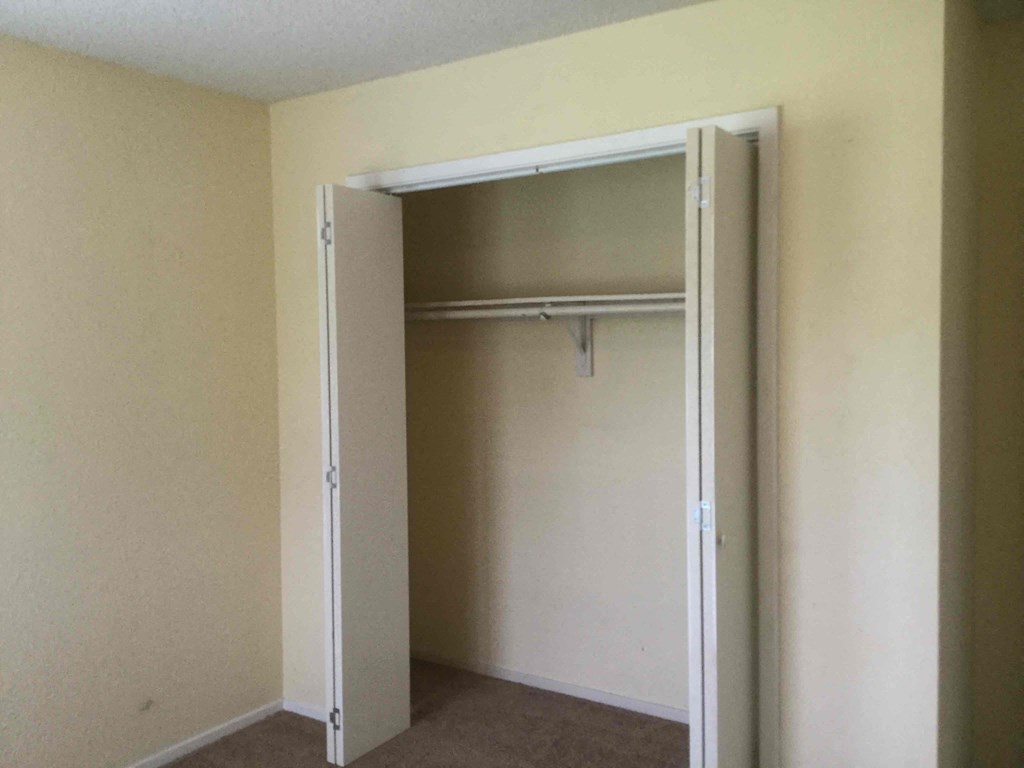 an empty closet in a room with a door open