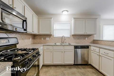 a kitchen with white cabinets and stainless steel appliances