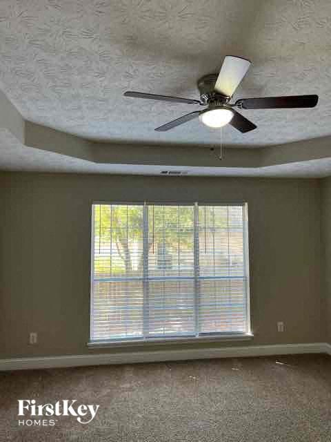 a ceiling fan in a room with a large window
