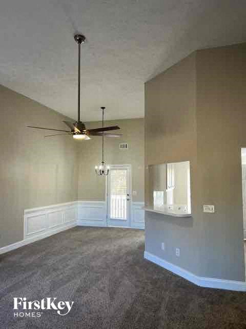 an empty living room with a ceiling fan