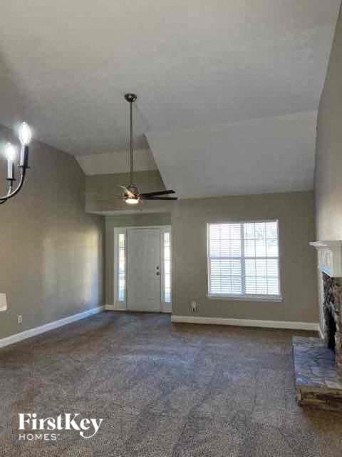 an empty living room with a ceiling fan