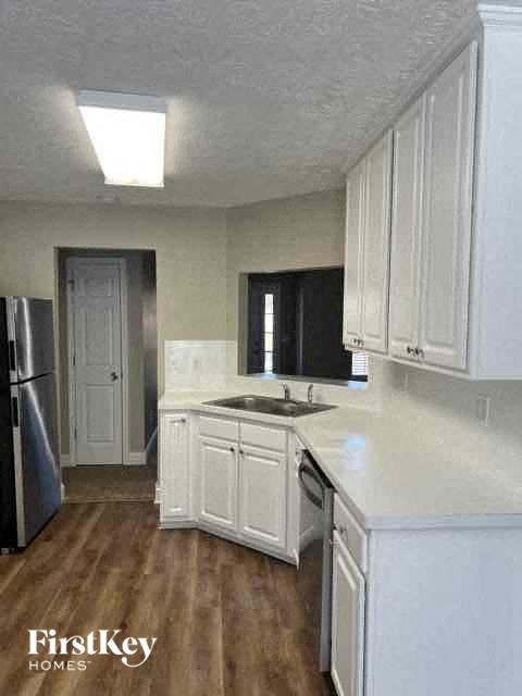 a kitchen with white cabinets and a sink and a refrigerator