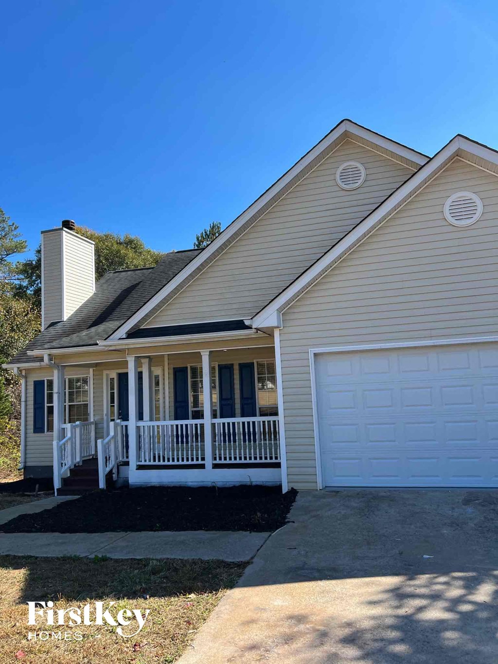 the front of a house with a porch and a white garage door