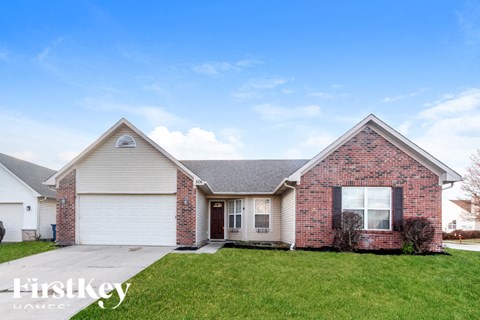 A brick house with a garage door and a sign that says "FirstKey Homes".