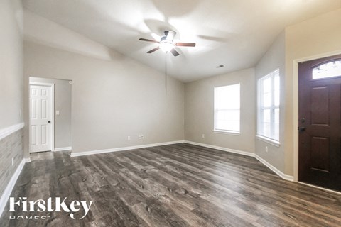 A room with wooden flooring and a ceiling fan.