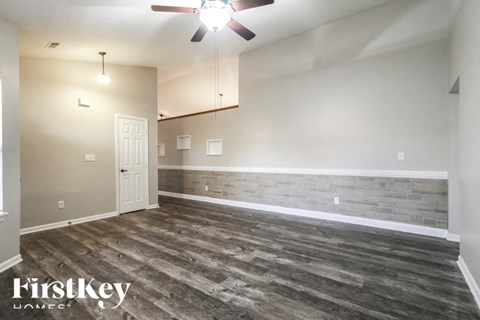 A room with wooden flooring and a ceiling fan.