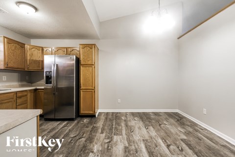 A kitchen with wooden cabinets and a refrigerator.