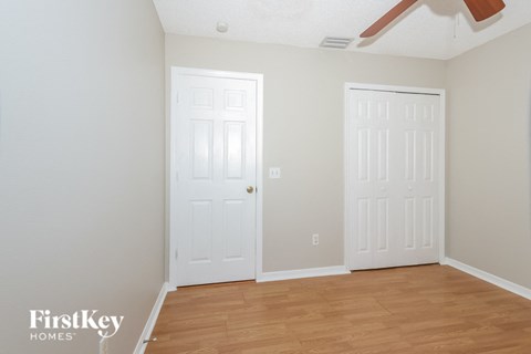 a bedroom with two white doors and a wood floor