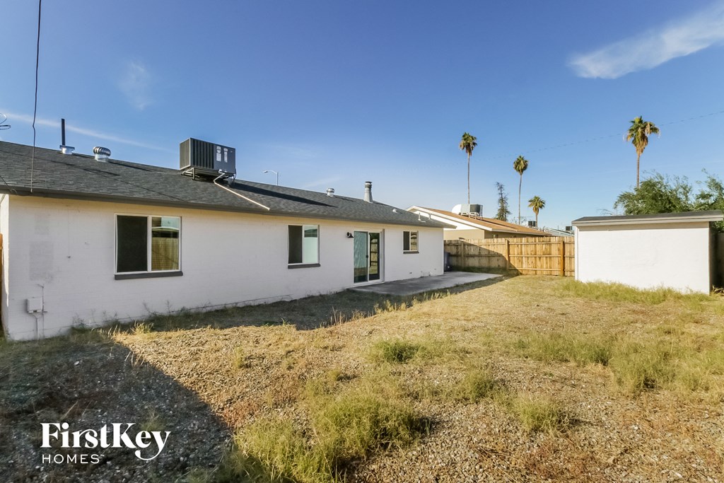 a white house with a yard and palm trees in the background