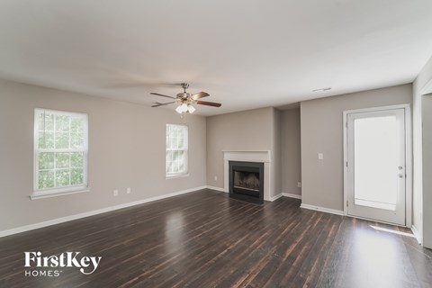 a living room with a ceiling fan and a fireplace