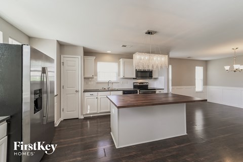 a large kitchen with white cabinets and stainless steel appliances