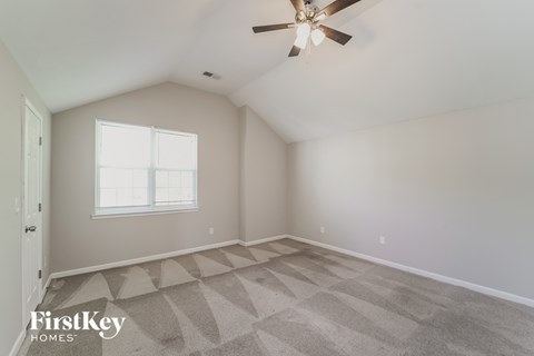 a bedroom with a ceiling fan and a window