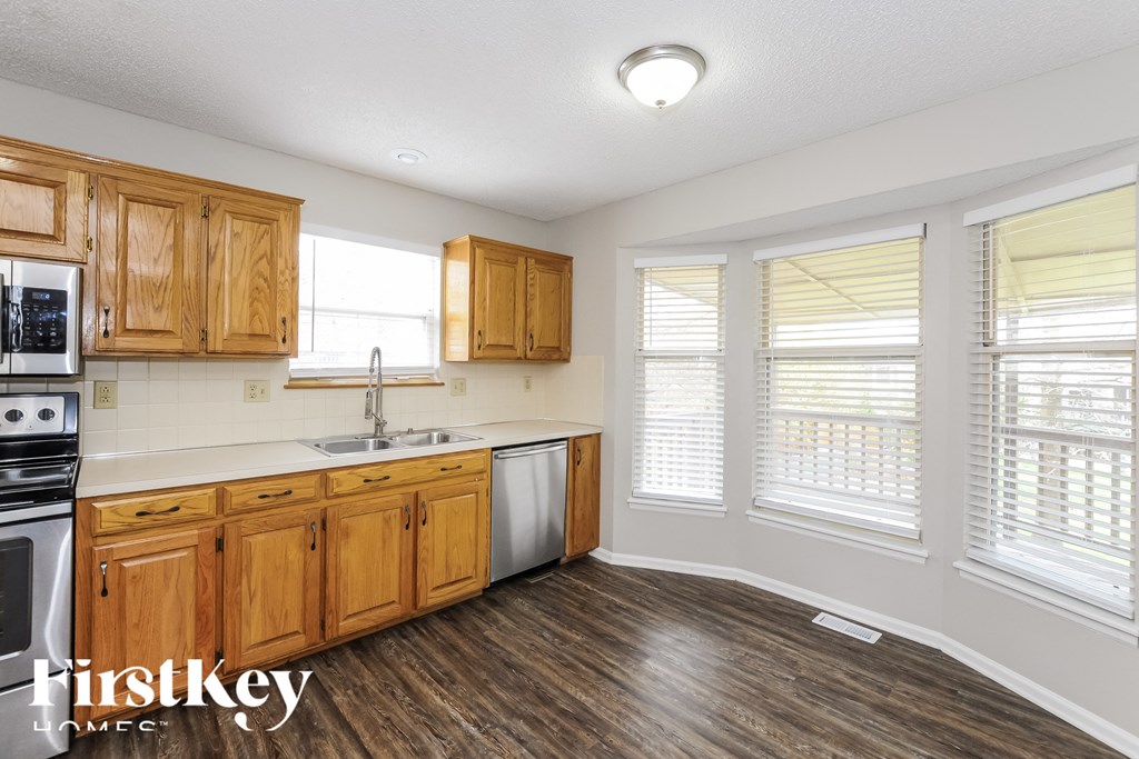 A kitchen with wooden cabinets and a stove top oven.