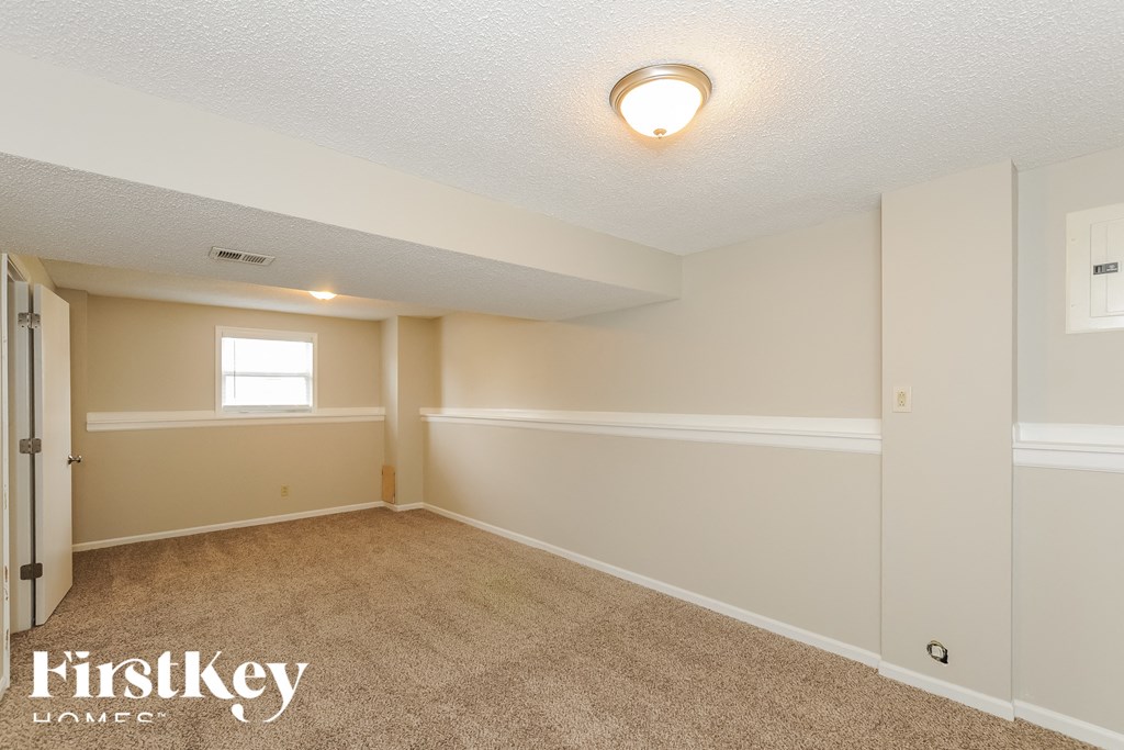 A room with a carpeted floor and a window.