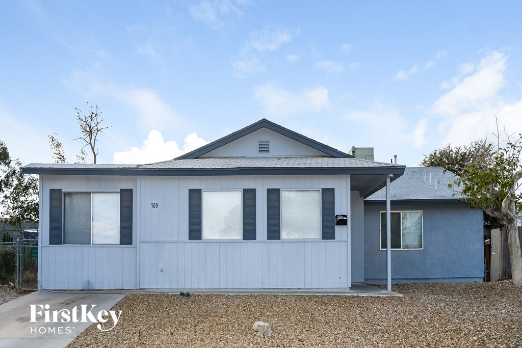 the front view of a small blue house with white windows