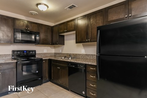 a kitchen with black appliances and granite counter tops