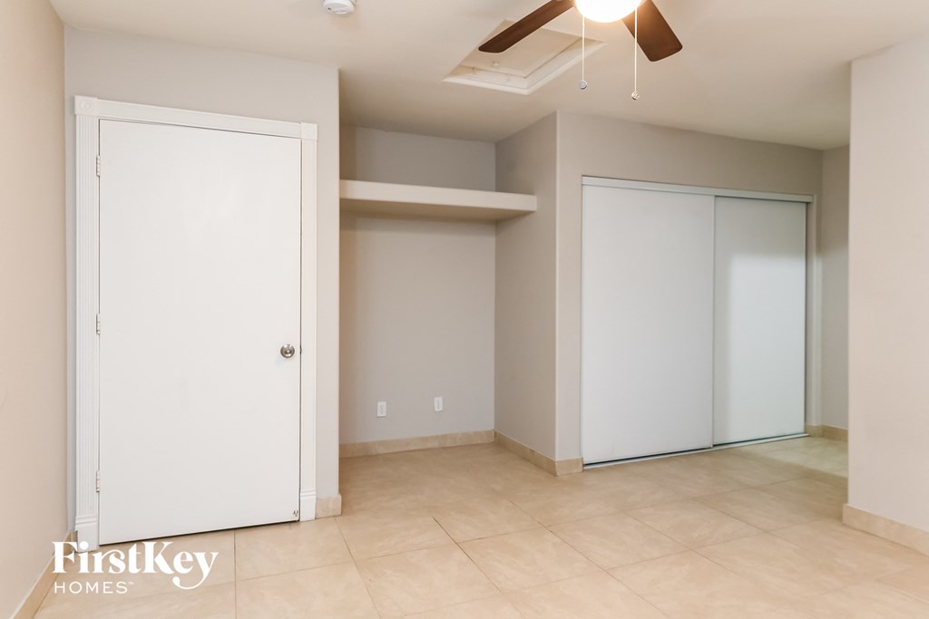 a empty room with a closet and a ceiling fan