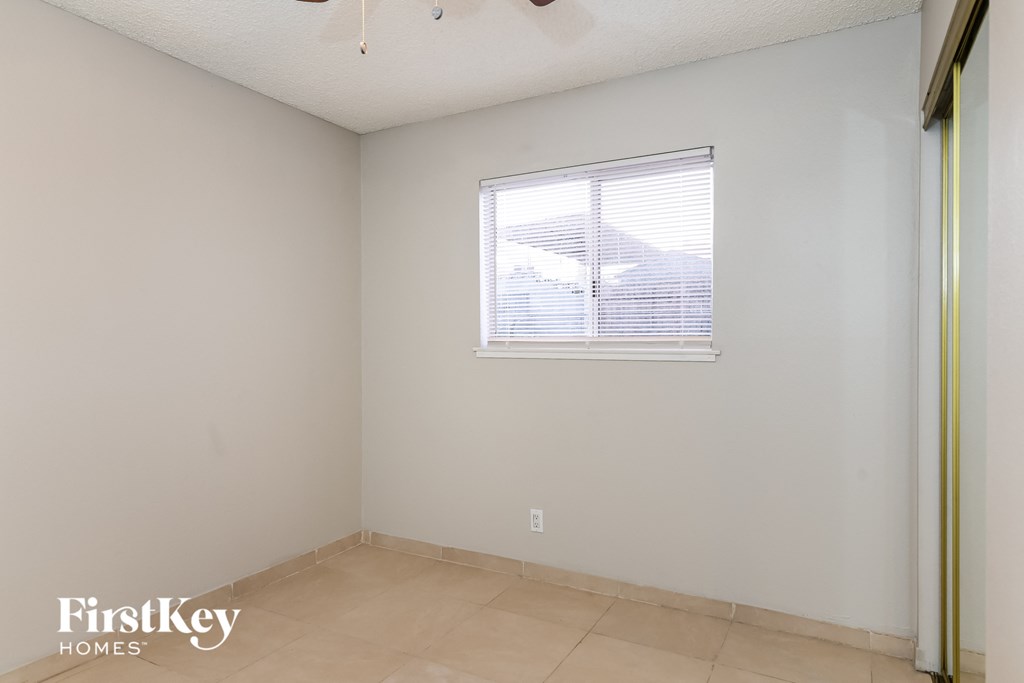 the living room of an empty house with a window and a tiled floor