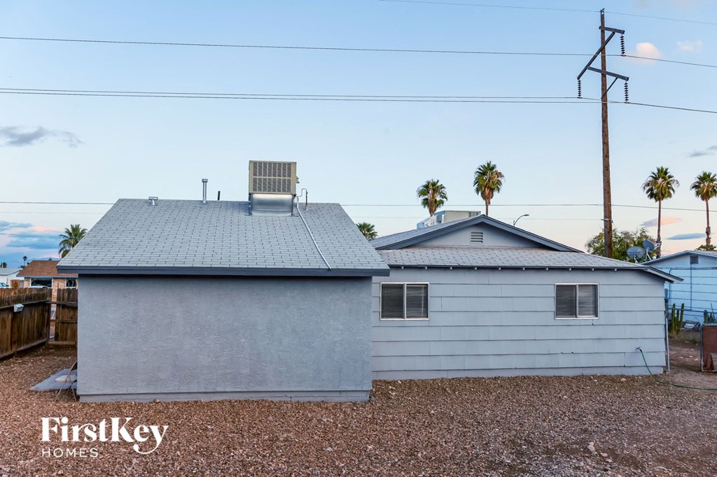a white house with a gray roof and palm trees
