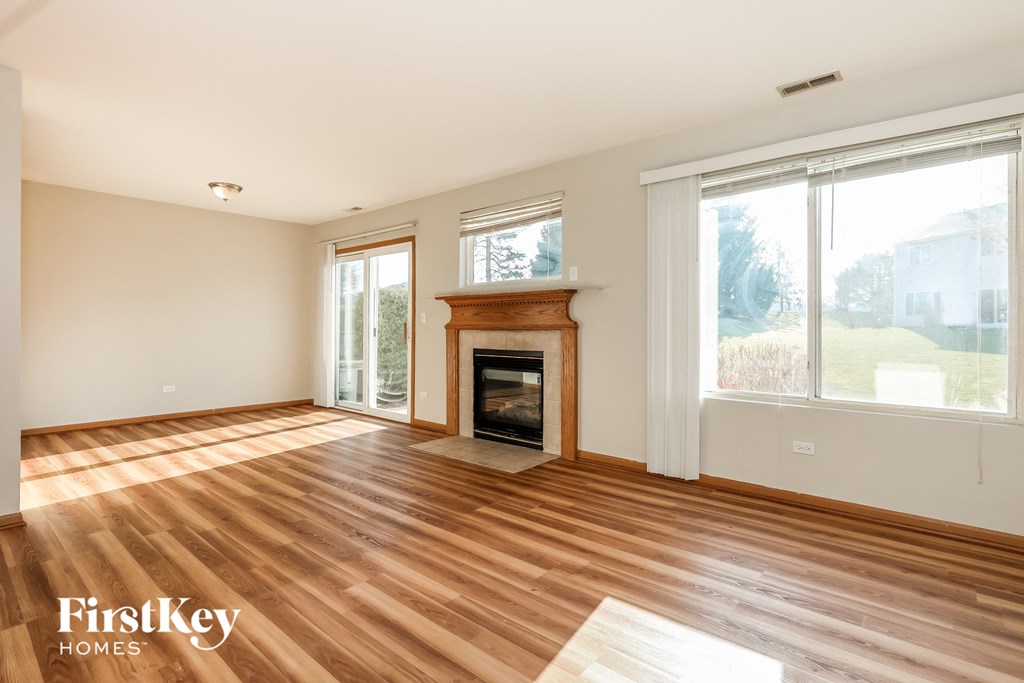 a living room with a fireplace and wooden floors
