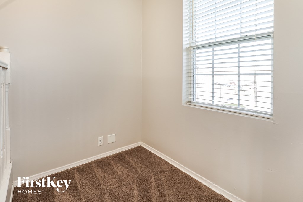 a corner of a room with a carpet and a window