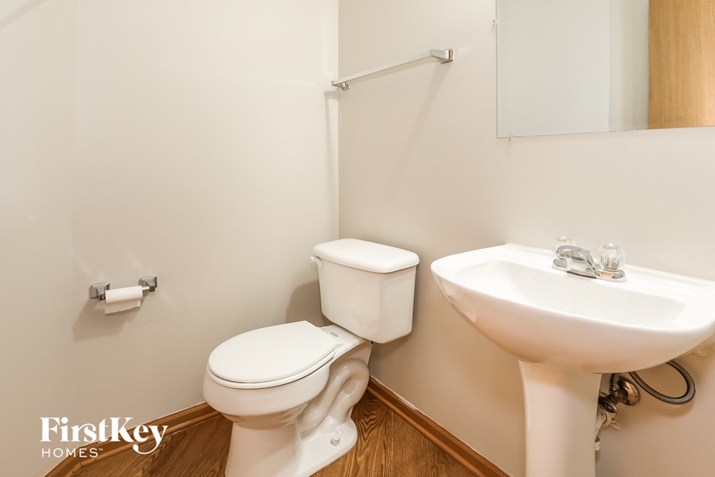 a bathroom with a toilet and a sink and a mirror